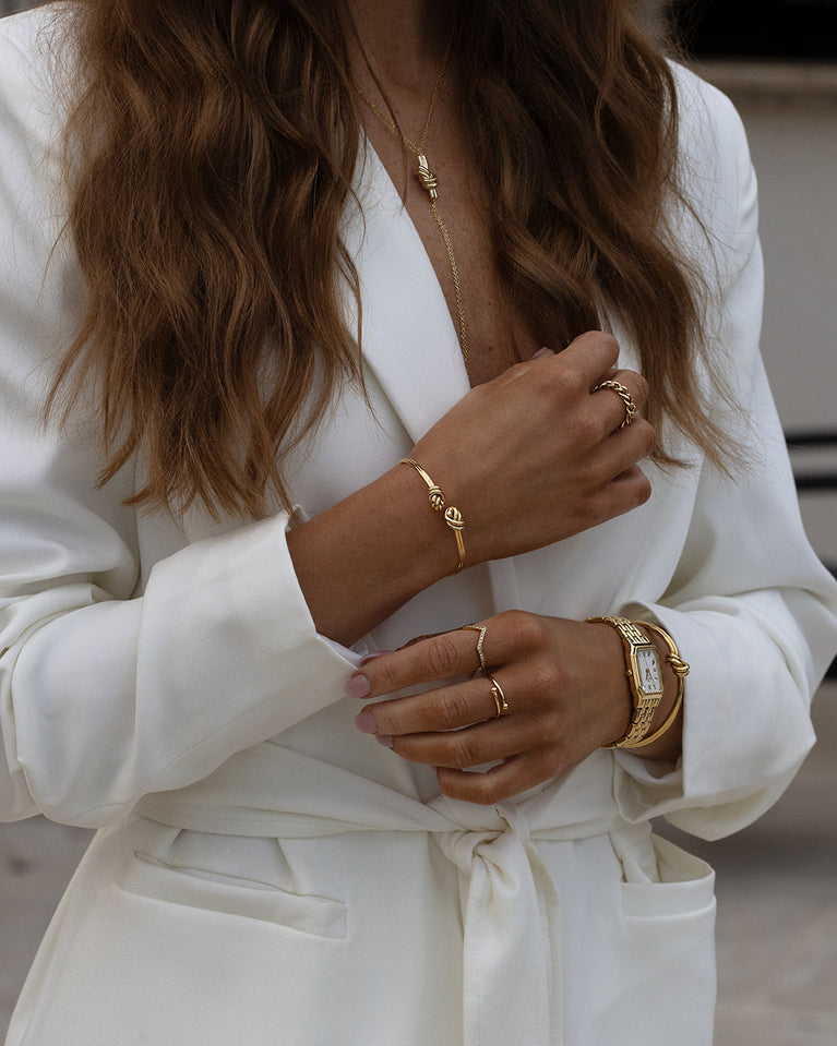 A Bangle Bracelet in polished Silver plated-316L stainless steel from Waldor & Co. The model is Dual Knot Bangle Polished.