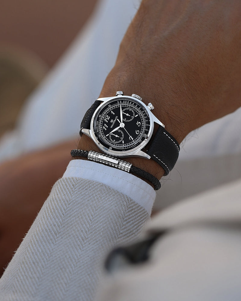 A round mens watch in Rhodium-plated 316L stainless from Waldor & Co. with black sunray dial. Curved mineral glass with 5 layers anti-reflective coating. Seiko VD32 movement. Genuine leather strap. The model is Avant 39 Eze.