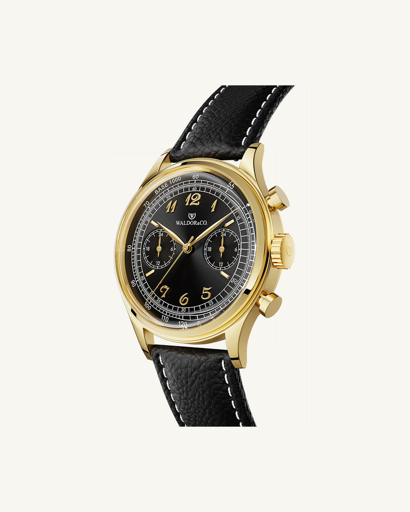 A round mens watch in 14K gold-plated 316L stainless steel from Waldor & Co. with black sunray dial. Curved mineral glass with 5 layers anti-reflective coating. Seiko VD32 movement. Genuine leather strap. The model is Avant 39 Eze.