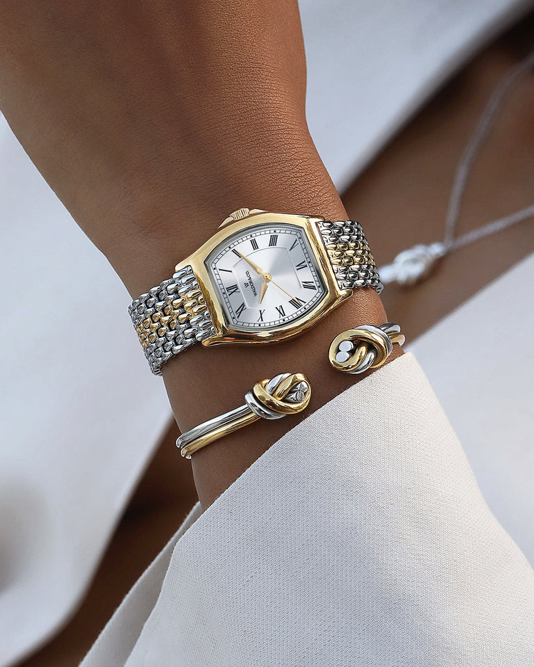 A square womens watch in 22k two-toned silver and gold plated 316L stainless steel from Waldor & Co. with domed mineral glass dial. Seiko movement. The model is Constant 36 Menaggio.