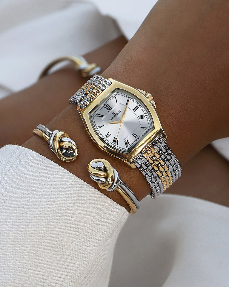 A square womens watch in 22k two-toned silver and gold plated 316L stainless steel from Waldor & Co. with domed mineral glass dial. Seiko movement. The model is Constant 36 Menaggio.