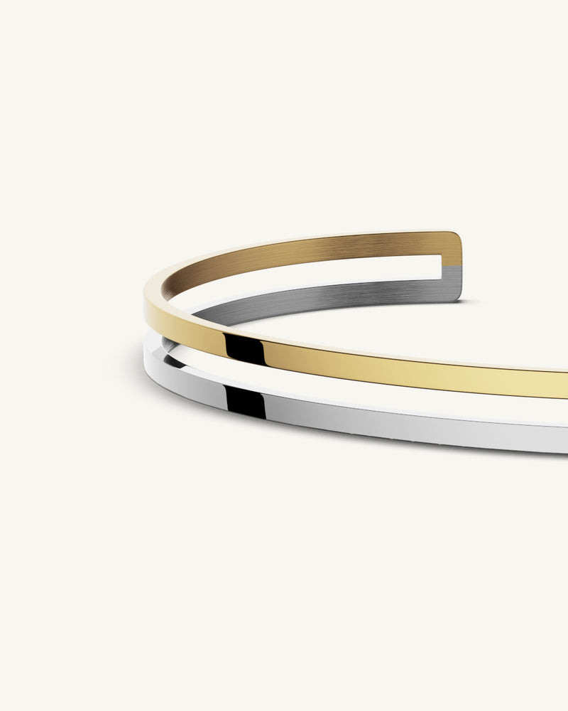A bangle in 14k gold-plated 316L stainless steel from Waldor & Co. One size. The model is Dual Bangle Polished.