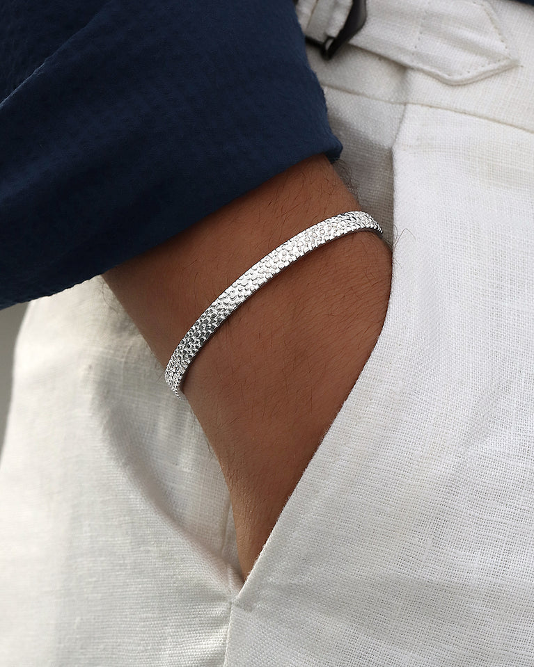 A polished stainless steel bangle in silver from Waldor & Co. One size. The model is Frost Bangle Polished.