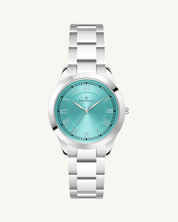 A round womens watch in silver from Waldor & Co. with turquoise sunray dial and a second hand. Seiko movement. The model is Imperial 32 Nocelle 32mm.