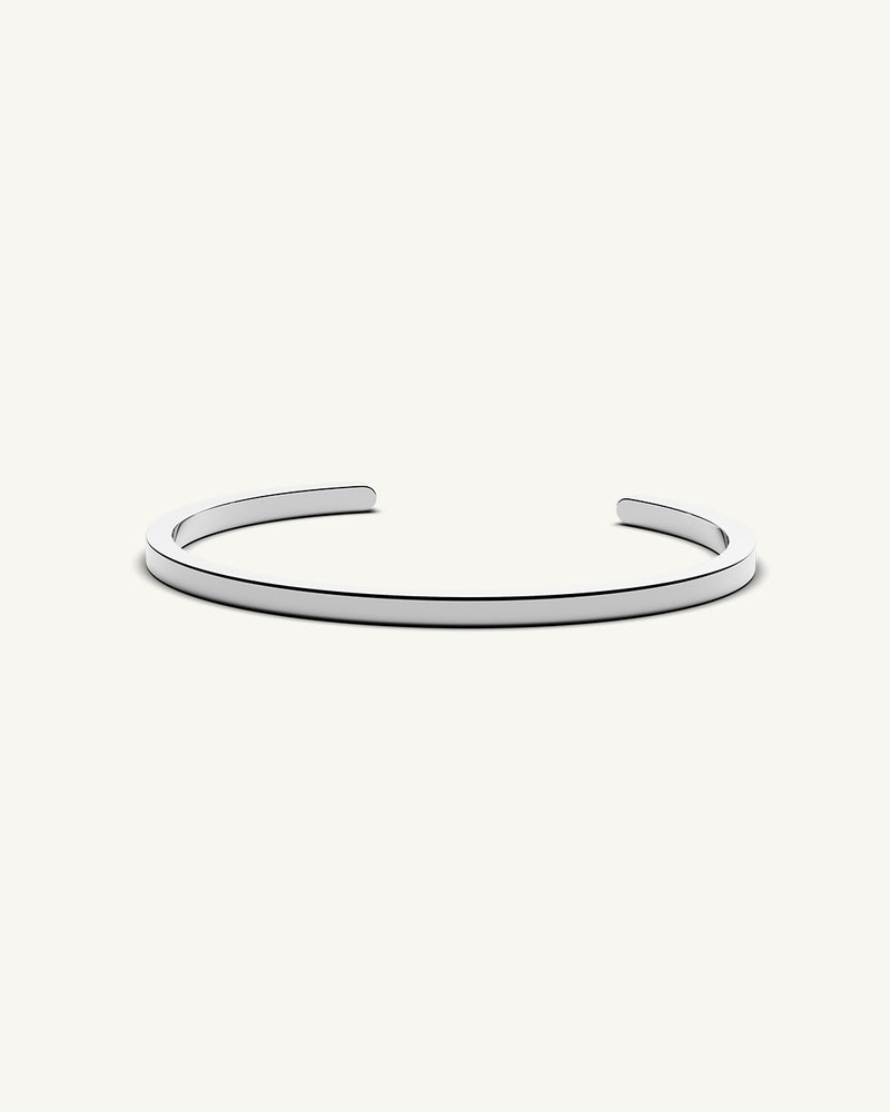 A polished stainless steel bangle in silver from Waldor & Co. One size. The model is Square Bangle Polished