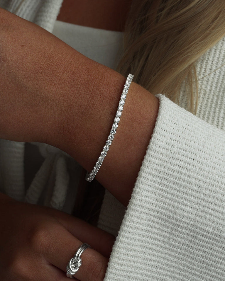 A polished stainless steel chain in silver with turquoise stones from Waldor & Co. The model is Tennis Chain Polished