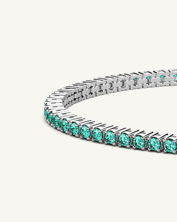 A polished stainless steel chain in silver with turquoise stones from Waldor & Co. The model is Tennis Chain Polished
