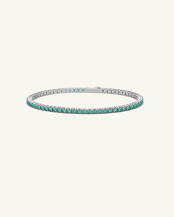 A polished stainless steel chain in silver with turquoise stones from Waldor & Co. The model is Tennis Chain Polished