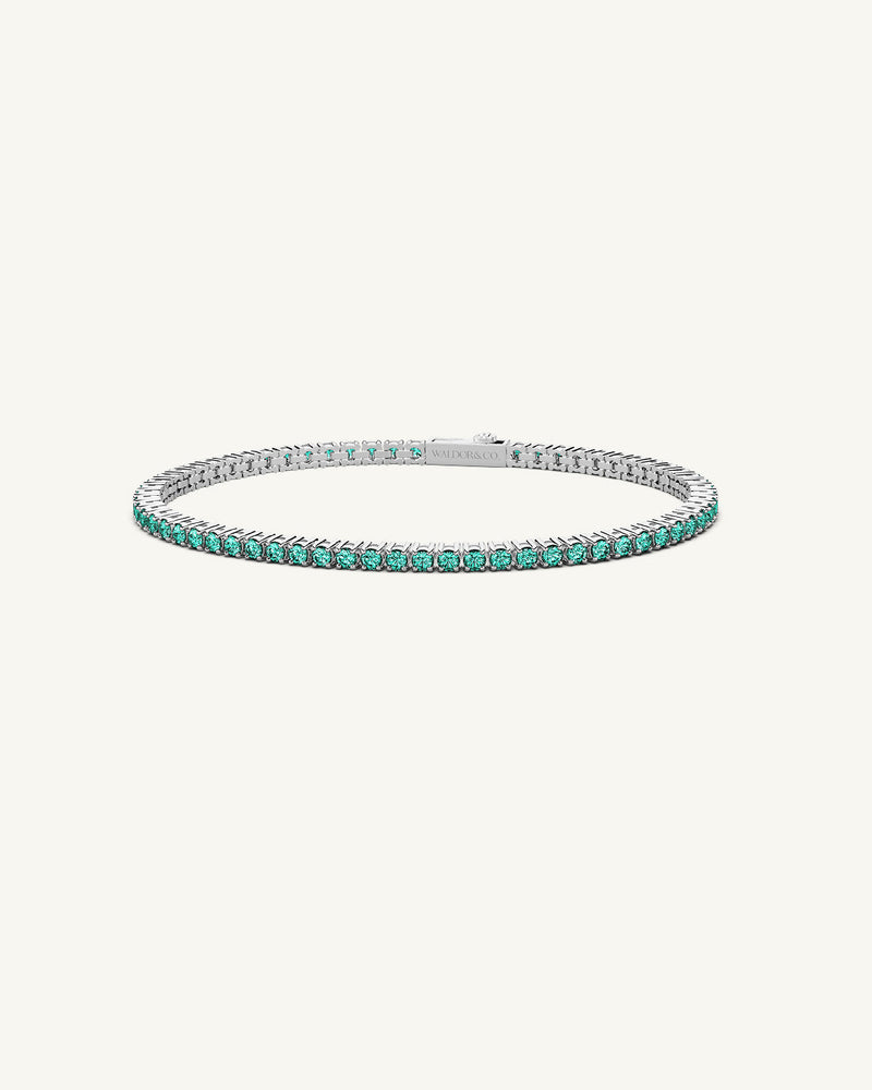 A polished stainless steel chain in silver with turquoise stones from Waldor & Co. The model is Tennis Chain Polished