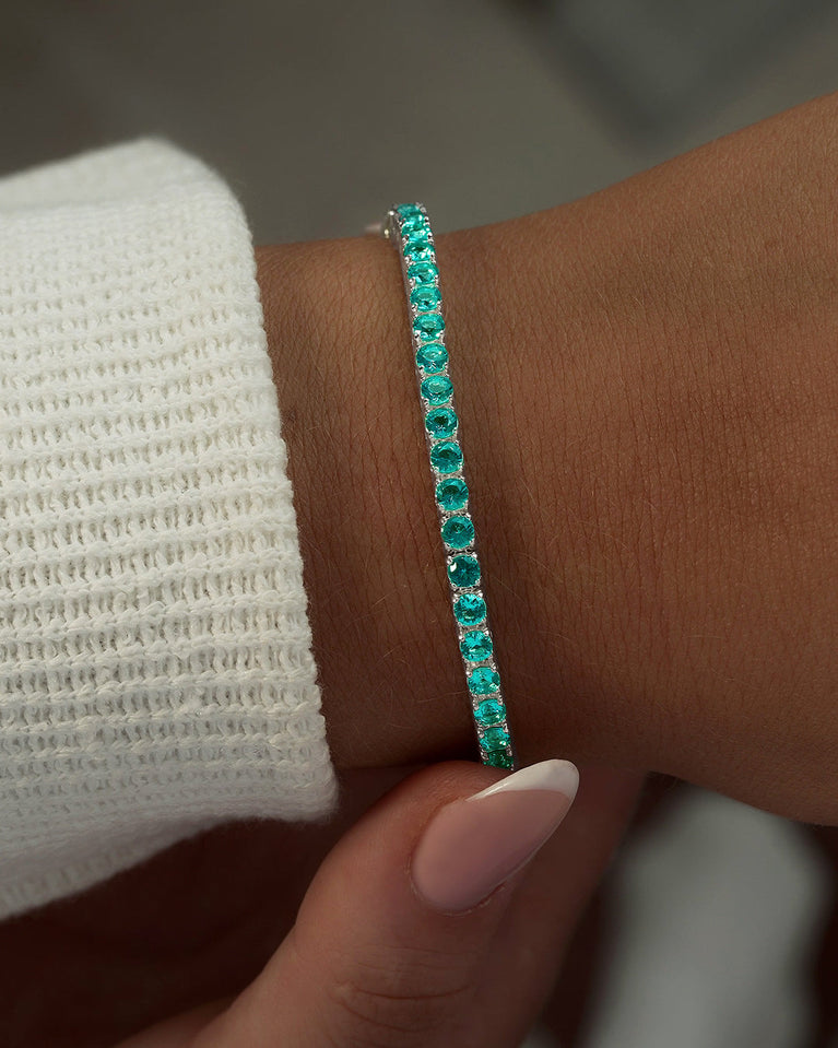 A polished stainless steel chain in silver with turquoise stones from Waldor & Co. The model is Tennis Chain Polished