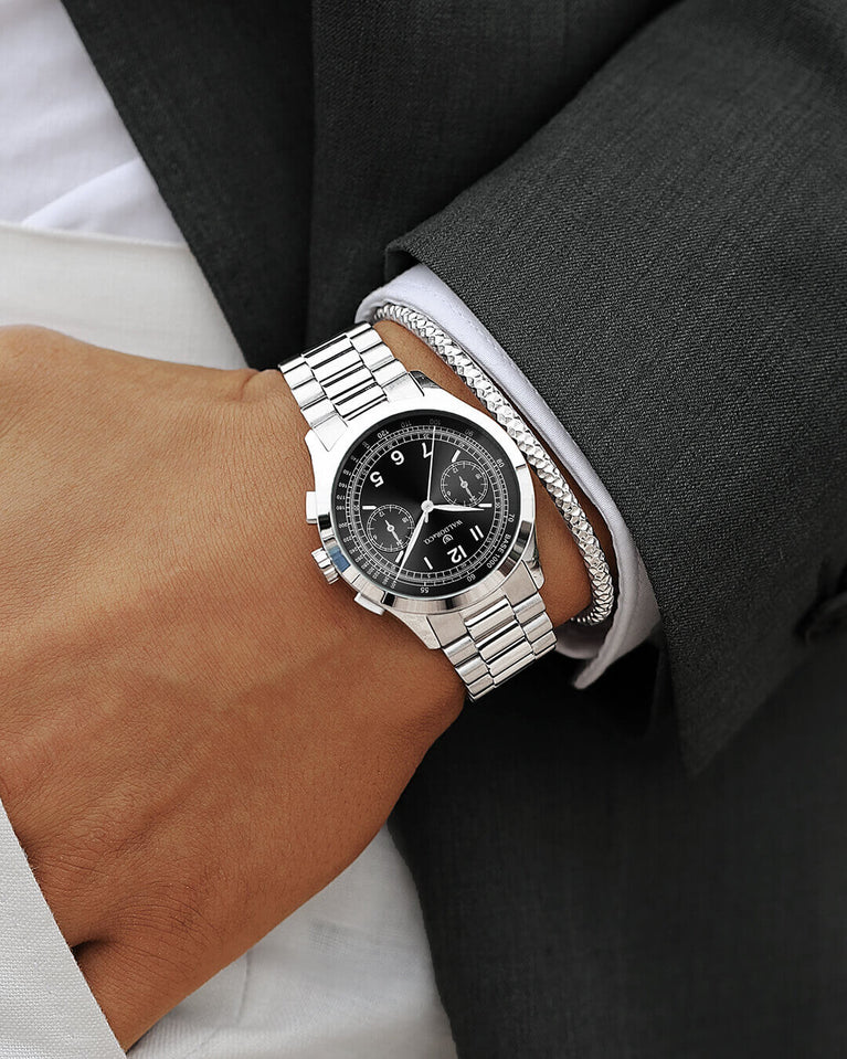 A round mens watch in rhodium-plated silver from Waldor & Co. with black sunray dial and a second hand. Seiko movement. The model is Chrono 39 Porto Cervo.