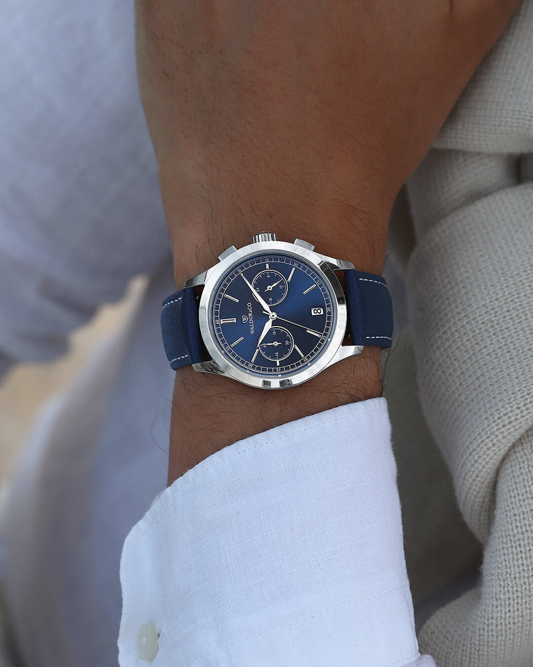 A round mens watch in rhodium-plated silver from Waldor & Co. with blue sunray dial and genuine blue leather strap. A second hand. Seiko movement. The model is Chrono 39 Sardinia 39mm.