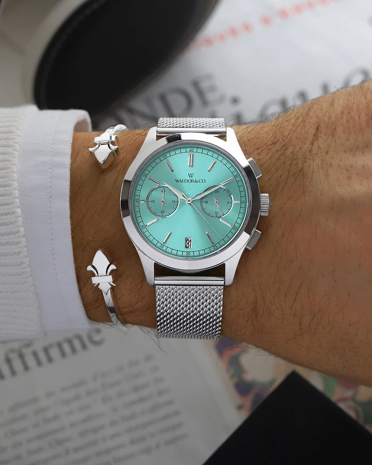 A round mens watch in rhodium-plated silver from Waldor & Co. with turquoise sunray dial and a second hand. Seiko movement. The model is Chrono 39 Sardinia 39mm.