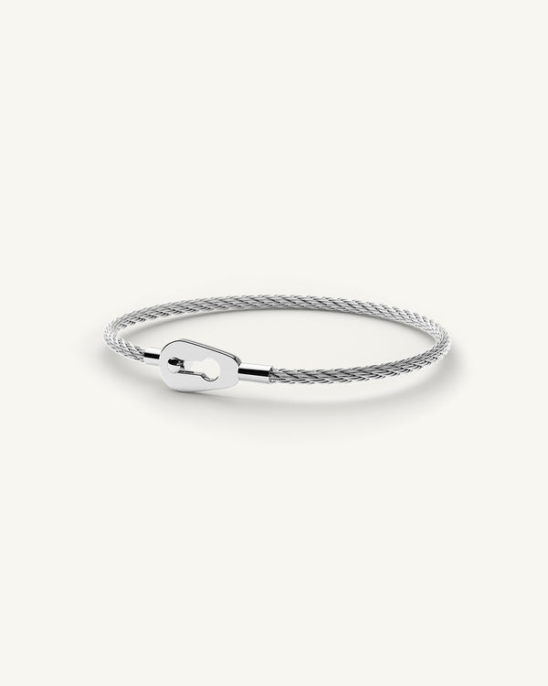 A polished stainless steel bangle in silver from Waldor & Co. One size. The model is Como Bangle Polished