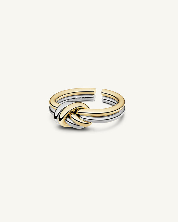 A polished stainless steel ring in 14k gold from Waldor & Co. One size. The model is Dual Knot Ring.