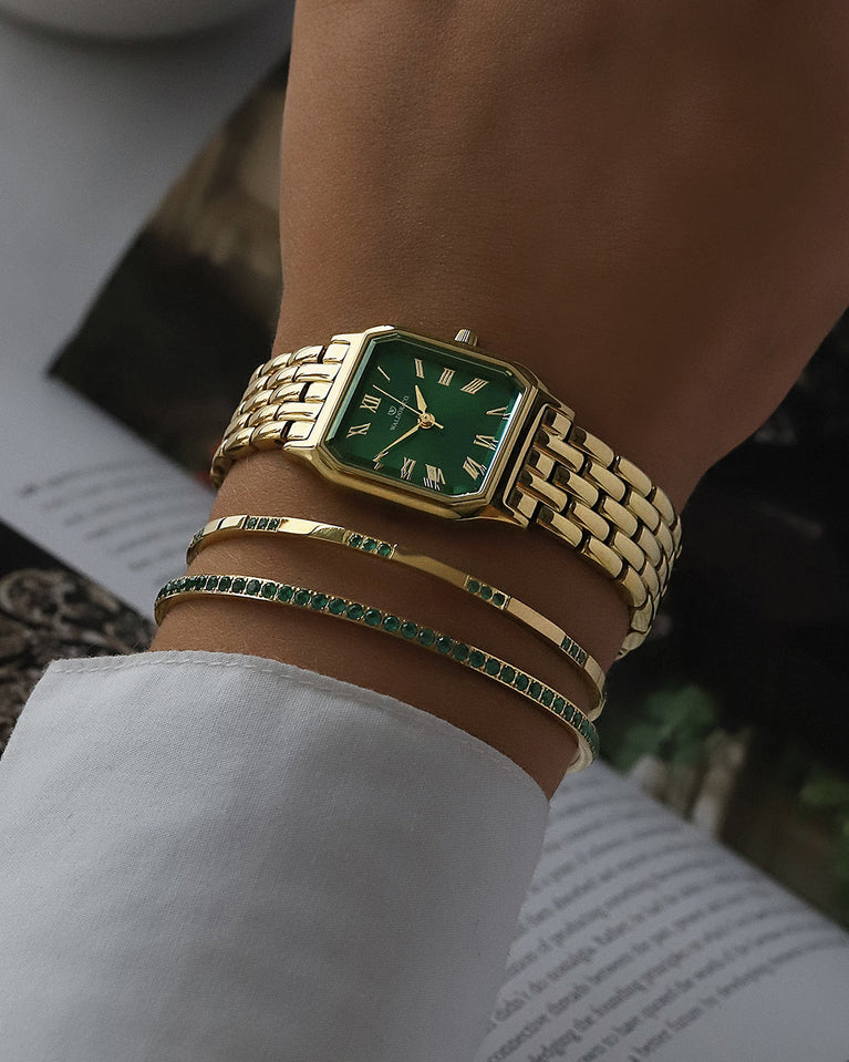 A square womens watch in 22k gold from Waldor & Co. with green Diamond Cut Sapphire Crystal glass dial. Seiko movement. The model is Eternal 22 Bellagio.