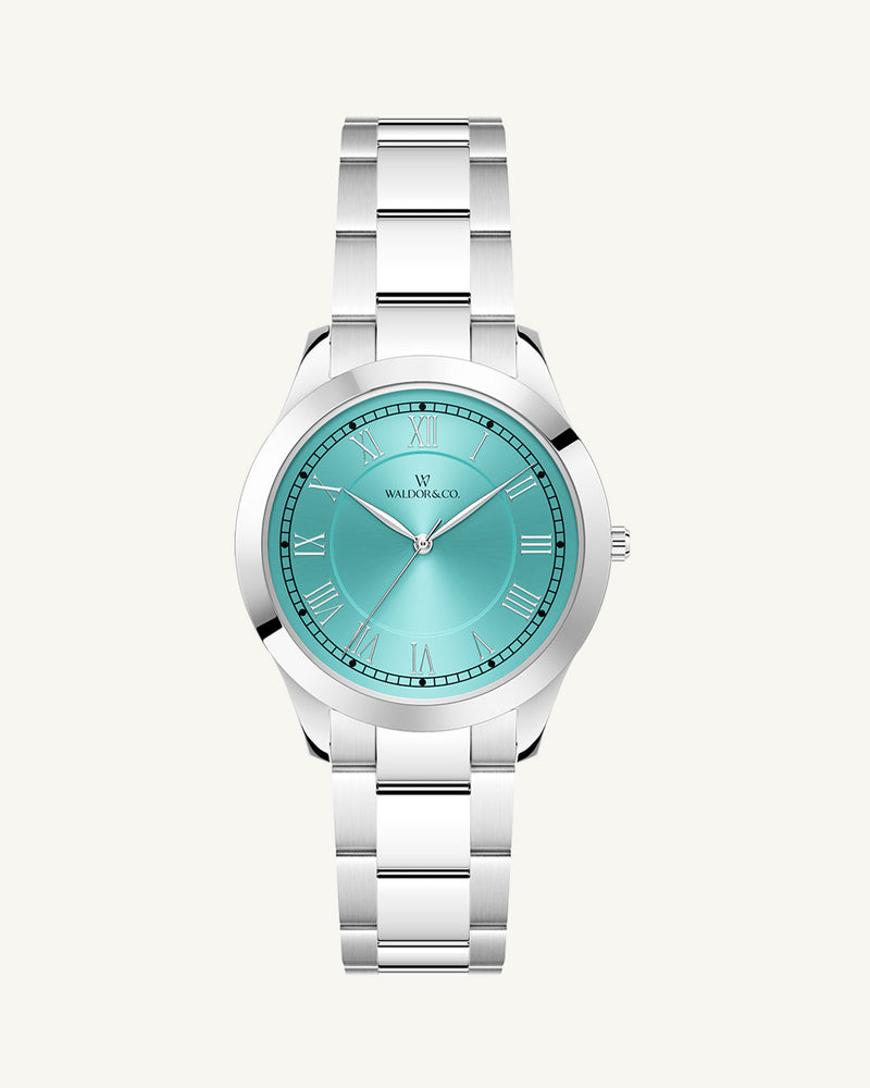 A round womens watch in silver from Waldor & Co. with turquoise sunray dial and a second hand. Seiko movement. The model is Imperial 32 Nocelle 32mm.