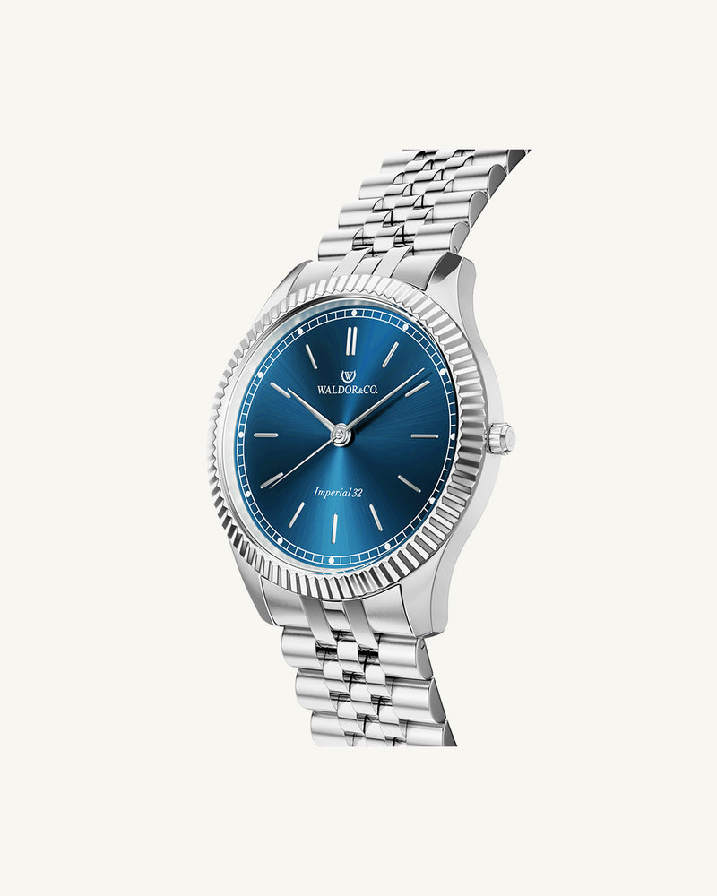 A round womens watch in silver from Waldor & Co. with blue sunray dial and a second hand. Seiko movement. The model is Imperial 32 Positano 32mm.